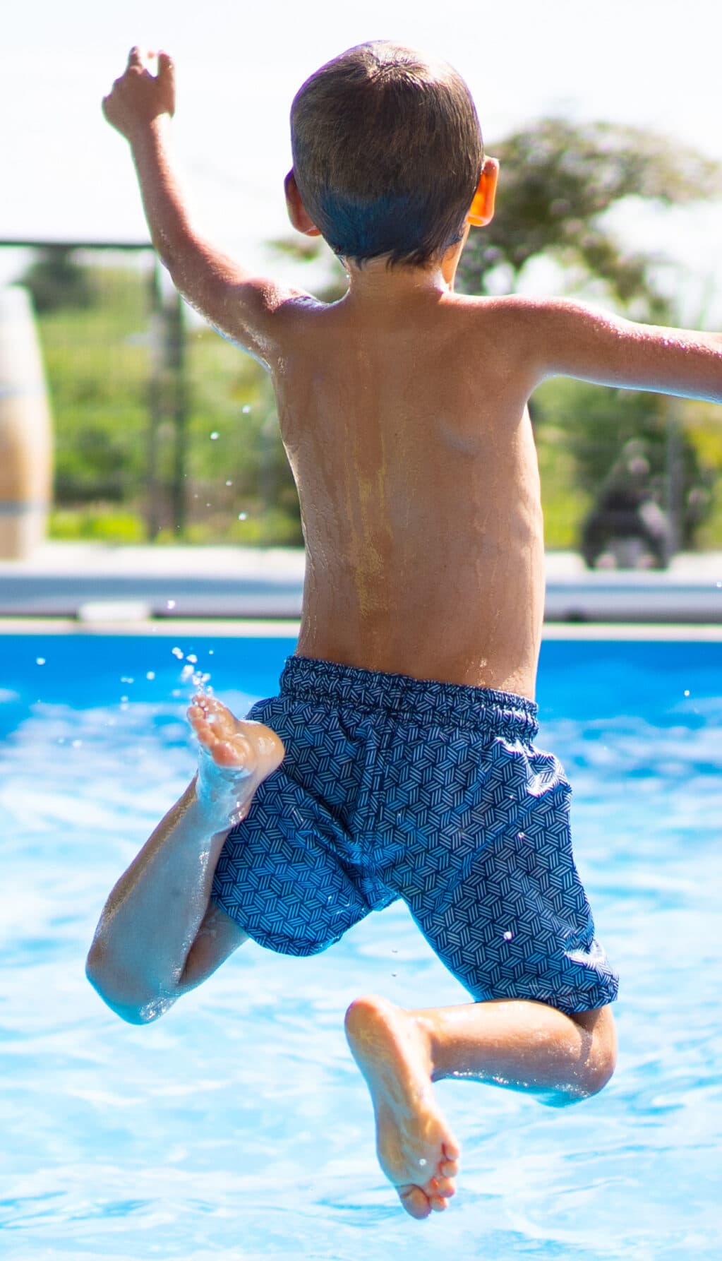 hello summer holidays – boy jumping in swimming pool